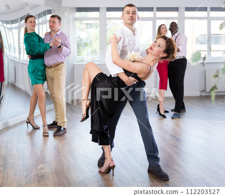 Woman dances incendiary tango with man partner during choreography lesson 112203527