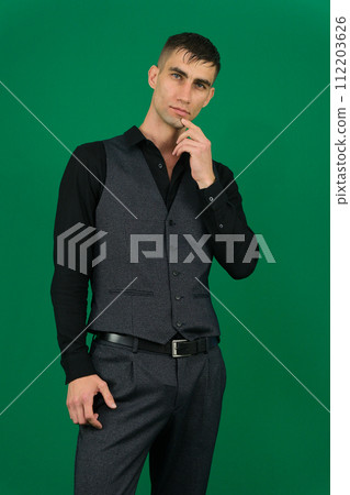 emotions of a handsome man guy on a green background chromakey close-up dark hair young man Full length portrait of a businessman in black vest with white shirt , with bow tie standing emotions of a handsome man guy on a green background chromakey close-up dark hair young man Full length portrait of a businessman in black vest with white shirt , with bow tie standing 112203626