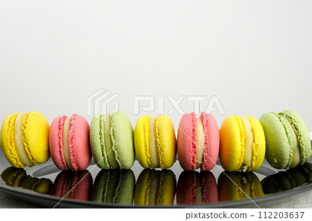 Line of yellow pink and green macaroons colourful pastel macarons isolated on white background Macaron colorful on table Line of yellow pink and green macaroons colourful pastel macarons isolated on white background Macaron colorful on table 112203637