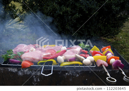 Shish kebab with mushrooms, cherry tomato and sweet pepper, Grilled meat skewers. Top view, copyspace. most important meat dish of Turkish cuisine kebabs is a rich product that is cooked on embers Shish kebab with mushrooms, cherry tomato and sweet pepper, Grilled meat skewers. Top view, copyspace. most important meat dish of Turkish cuisine kebabs is a rich product that is cooked on embers 112203645