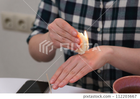The process of making a massage candle using ingredients oils and wax measure weigh stir add close-up of women's hands. food thermometer measure wax temperature women's party women witches witchcraft 112203667