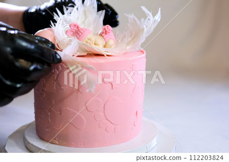 decoration of a cake for a family christening pink cake with footprints of small child on top of angel wings and baby in pink diaper a girl how to find out gender of child with the help of a cake 112203824