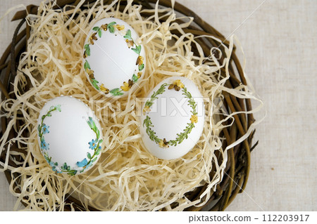 banner a lot of space for text coffee background Easter eggs decorated with painted embroidery ribbons on eggshell in nest three white eggs then on shavings advertising invitation postcard bigboard 112203917