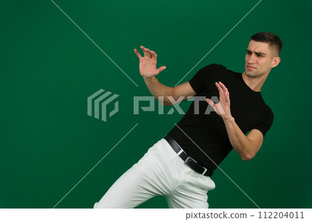 Side view portrait of a businessman punching isolated on a green background 112204011