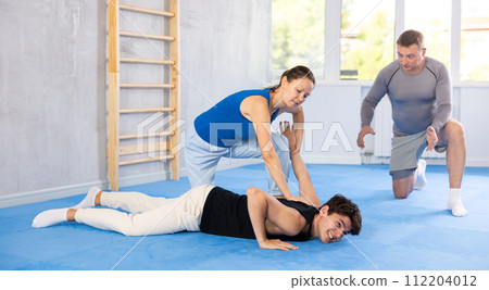 Woman learns to make power grab against male attacker under guidance of trainer. Self-defense class 112204012