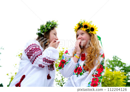 girls smiling having fun Ukrainian national costumes traditions girls resting in nature conversations gossip wreath of sunflowers and green grass with white flowers forest mavki beautiful women girls smiling having fun Ukrainian national costumes traditions girls resting in nature conversations gossip wreath of sunflowers and green grass with white flowers forest mavki beautiful women 112204126