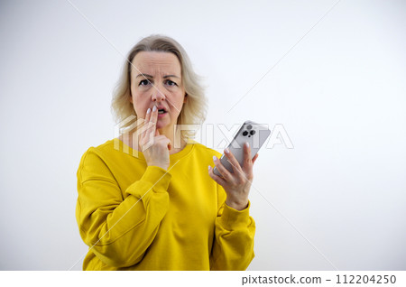 alarm phone frightened experience an adult woman with a phone in her hands put two fingers to her lips thinking upset unexpectedness unpleasant sensations and negative emotions alarm phone frightened experience an adult woman with a phone in her hands put two fingers to her lips thinking upset unexpectedness unpleasant sensations and negative emotions 112204250