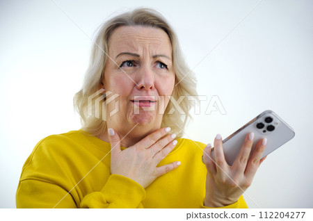 sore throat vocal cords tense woman can't speak she sticks out tongue looks up wrinkled hand she holds throat white clothes white background place for text blond hair 40-50 years old 112204277