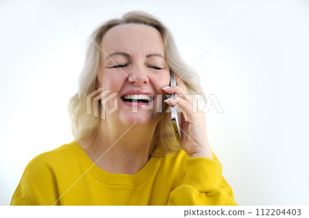 Portrait of attractive cheerful grey-haired woman sitting on divan talking on phone cellular at home house flat indoors 112204403