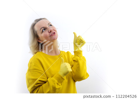 Smiling young redhead woman girl in casual yellow hoodie posing isolated on white background studio portrait. People sincere emotions lifestyle concept. Mock up copy space. Pointing thumbs on herself 112204526