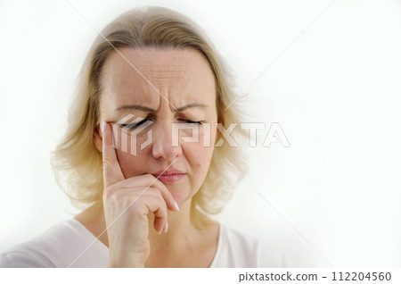 Unhappy woman touching hair, sitting on floor at home, thinking about problems, upset girl feeling lonely and sad, psychological and mental troubles, suffering from bad relationship or break up 112204560