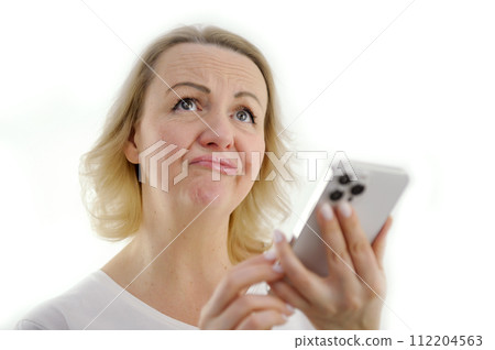 disappointment sadness rejection woman on white background is disappointed to fold her lips Like a duckling with a tube raise her eyes up in her hands a white phone disappointment sadness rejection woman on white background is disappointed to fold her lips Like a duckling with a tube raise her eyes up in her hands a white phone 112204563