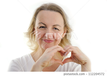 Happy millennial girl hold hands at heart chest feel thankful pray to God at workplace, calm peaceful young woman believer grateful for luck or fate, faith, superstition, gratitude concept 112204572