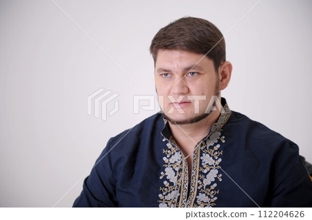 Waist-up shot of serious-looking unemotional good-looking adult man in gray t-shirt looking at camera calm and strict, being snob and hard to impress standing over gray background. Waist-up shot of serious-looking unemotional good-looking adult man in gray t-shirt looking at camera calm and strict, being snob and hard to impress standing over gray background. 112204626