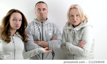 three dissatisfied indignant people a man two women a young teenage girl middle-aged people look evilly into the frame and dance an angry look 112204649