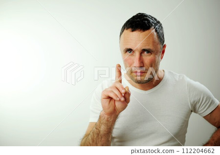 look here attention man screwed up eyes raised index finger up serious and attracts attention about something he wants to say free space for advertising it is interesting it is curious buy come sale 112204662