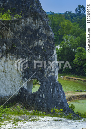 A scenic landscape photo of road through towering white Limestone rock formations 112204698