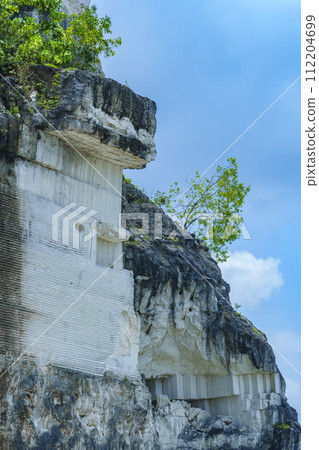 A scenic landscape photo of road through towering white Limestone rock formations A scenic landscape photo of road through towering white Limestone rock formations 112204699