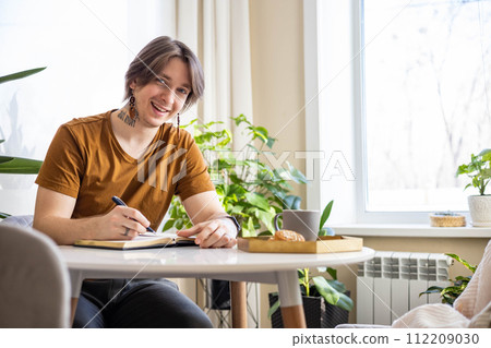 Stylish confident guy writing in journal Stylish confident guy writing in journal 112209030