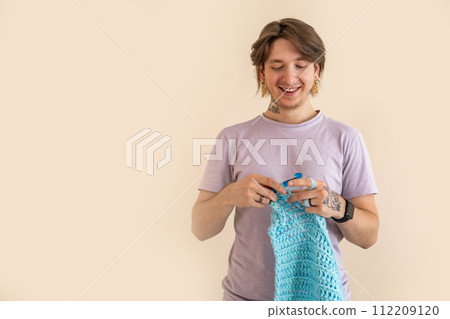 Portrait hipster man enjoy crochet handmade with crocheting supplies art hobby closeup 112209120
