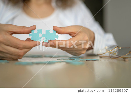 Business woman hands assembling puzzle details concept of finding solution solving problem top view Business woman hands assembling puzzle details concept of finding solution solving problem top view 112209307