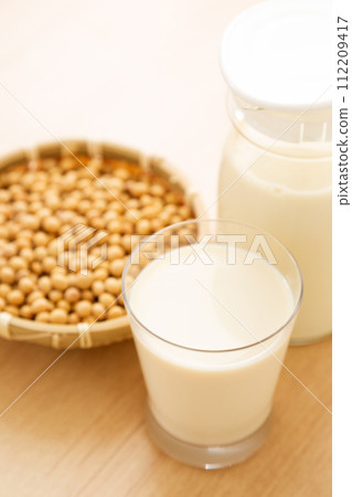 Soy milk and soybeans in glasses and pitchers 112209417