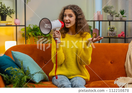 Teenager child girl kid talking with megaphone, proclaiming news, loudly announcing advertisement Teenager child girl kid talking with megaphone, proclaiming news, loudly announcing advertisement 112210878