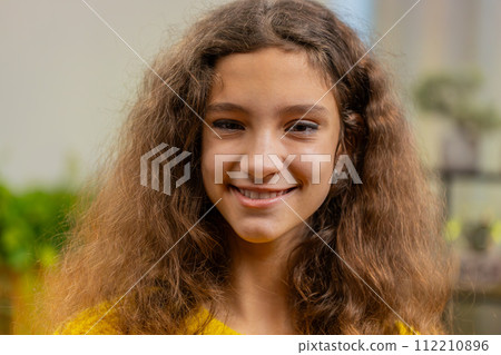 Portrait of happy smiling Caucasian 15 years school girl child kid looking at camera, home play room 112210896