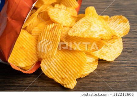 Potato chips, delicious BBQ seasoning spicy for crips, thin slice deep fried snack fast food in open bag. 112212606