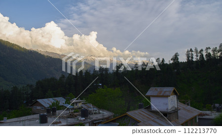 A vast landscape with clear skies, clouds, and snowy mountains. 112213770