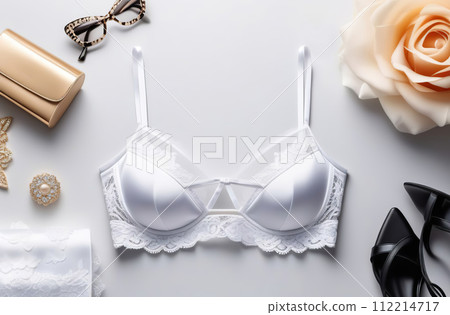 White lacy lingerie on white background. Sexy bra, panties flat lay, top view. Horizontal banner with copy space for text. No people. Fashion lingerie set, essential accessory and stylish underwear. 112214717