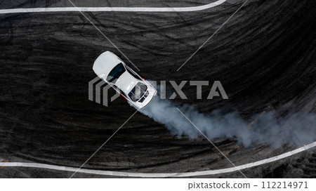 Aerial top view car drifting diffusion race drift car with lots of smoke from burning tires on speed track, Professional driver drifting car with lots of white smoke . 112214971