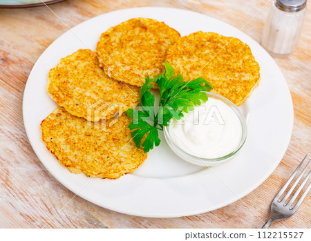 Fried potato pancakes latke are neatly laid out on plate and decorated with parsley leaves. 112215527