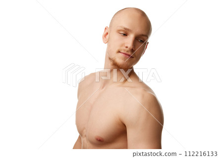 Handsome bald young guy with unshaved face, muscular body, standing shirtless isolated against white studio background 112216133