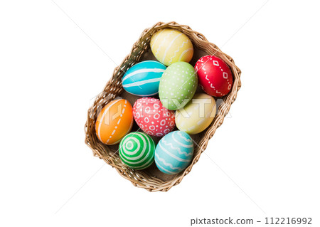 Basket of colorful Easter eggs isolated on white background. Easter basket filled with colored eggs top view holiday concept 112216992