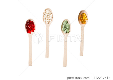 Top view Variety of vitamin and mineral pills in wooden spoon on Colored background. Top view of assorted pharmaceutical medicine pills. Dietary supplement healthcare product Top view Variety of vitamin and mineral pills in wooden spoon on Colored background. Top view of assorted pharmaceutical medicine pills. Dietary supplement healthcare product 112217318