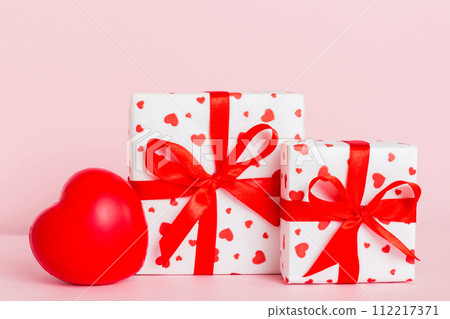 gift box with red bow and red heart on colored background. Perspective view. Flat lay 112217371