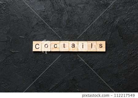 cocktails word written on wood block. cocktails text on cement table for your desing, concept cocktails word written on wood block. cocktails text on cement table for your desing, concept 112217549