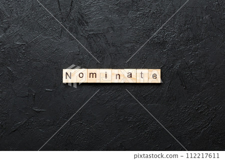 nominate word written on wood block. nominate text on table, concept nominate word written on wood block. nominate text on table, concept 112217611