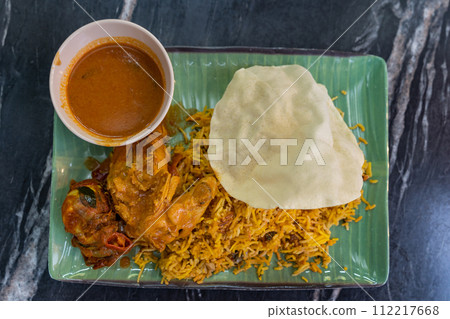 Top view of the biryani rice with curry chicken and papadam 112217668