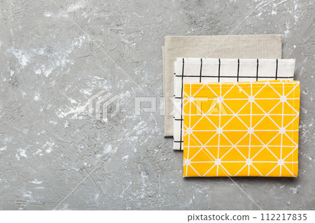top view with yellow empty kitchen napkin isolated on table background. Folded cloth for mockup with copy space, Flat lay. Minimal style top view with yellow empty kitchen napkin isolated on table background. Folded cloth for mockup with copy space, Flat lay. Minimal style 112217835