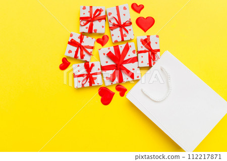 Gift boxes pop out from paper bag top view on colored background. bag packing handmade boxes fall out Concept of holidays, shopping, sale, discounts. Top view, flat lay 112217871