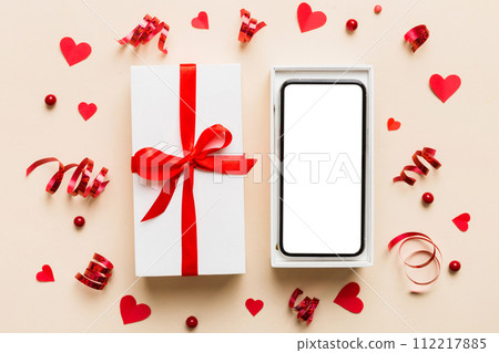 Opened gift box with ribbon and phone on color background, top view. Blank open box packaging mockup , Template for your design - branding mockup 112217885
