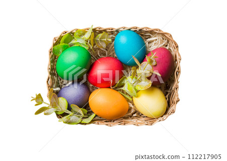 Basket of colorful Easter eggs isolated on white background. Easter basket filled with colored eggs top view holiday concept 112217905