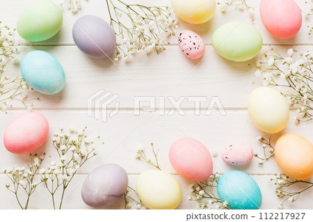 Happy Easter composition. Easter eggs on colored table with gypsophila. Natural dyed colorful eggs background top view with copy space Happy Easter composition. Easter eggs on colored table with gypsophila. Natural dyed colorful eggs background top view with copy space 112217927