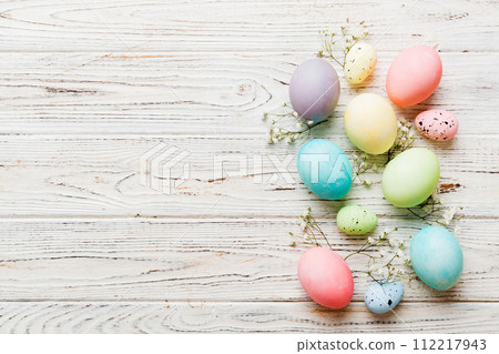 Happy Easter composition. Easter eggs on colored table with gypsophila. Natural dyed colorful eggs background top view with copy space Happy Easter composition. Easter eggs on colored table with gypsophila. Natural dyed colorful eggs background top view with copy space 112217943