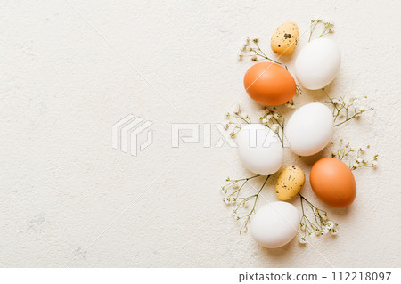 Happy Easter composition. Easter eggs on colored table with gypsophila. Natural dyed colorful eggs background top view with copy space 112218097