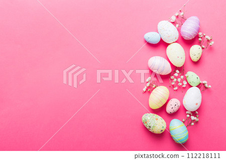 Happy Easter composition. Easter eggs on colored table with gypsophila. Natural dyed colorful eggs background top view with copy space 112218111