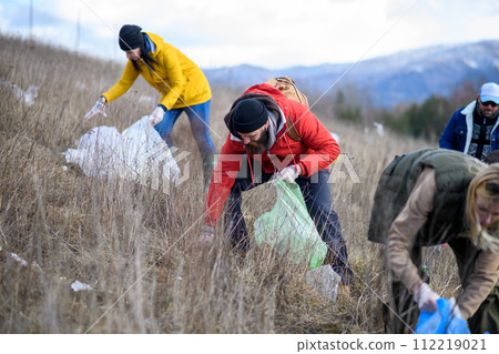 Group of activists picking up litter in nature, environmental pollution, eco activism. and plogging concept. 112219021