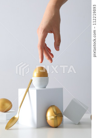 Golden eggs with a fork, knife and white cubes 112219893